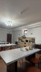 a large room with a table and chairs and a kitchen at Достык Хостел in Almaty