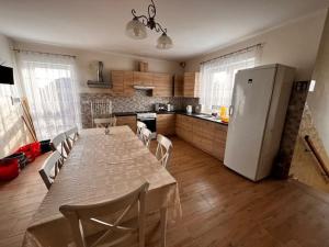 a kitchen with a table with chairs and a refrigerator at IWA Noclegi dla pracowników in Moczadła