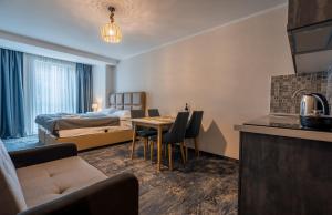 une chambre d'hôtel avec un lit et une table dans l'établissement New Gudauri Redco Premium Apartments, à Goudaouri