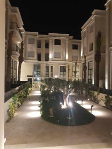 a building with a tree in front of it at night at Olfa cosy appart in La Marsa