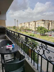 a table and chairs on a balcony with a view of a city at Entire 3BDR apartment at prime location with wifi and garden view near CAI airport in Cairo