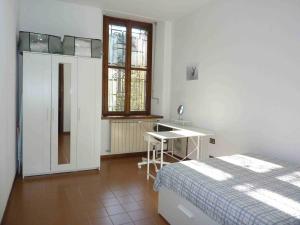 une chambre avec un lit, un bureau et une fenêtre dans l'établissement Casa Corsini, à Porto Valtravaglia