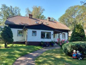 a small white house with two children sitting in the yard at Stara Brožnja eGbR in Burg