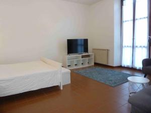 un salon avec un lit et une télévision à écran plat dans l'établissement Casa Corsini, à Porto Valtravaglia