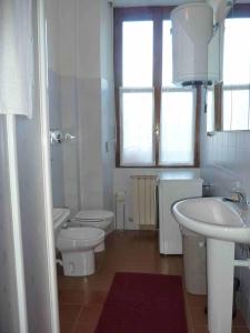 une salle de bains blanche avec toilettes et lavabo dans l'établissement Casa Corsini, à Porto Valtravaglia