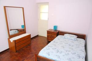 a bedroom with a bed and a dresser and a mirror at Tambarina Guest House in Mindelo