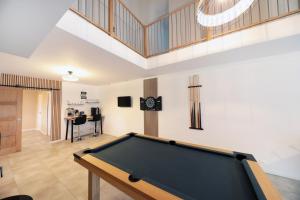 a pool table in a living room with a ceiling at La ferme d aumontzey in Aumontzey
