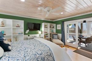 a bedroom with a bed and a flat screen tv at Live Oak Retreat - 2104 Bruce Drive in Saint Simons Island +28 photos