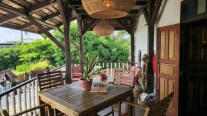 a porch with a wooden table and chairs on a balcony at Greenheart Boutique Hotel in Paramaribo