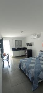 een slaapkamer met een bed en een tafel en een keuken bij RC FLAT Studio 05 Tamandaré, à 200m da praia in Tamandaré