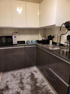 a kitchen with a sink and a microwave at Entire 3BDR apartment at prime location with wifi and garden view near CAI airport in Cairo