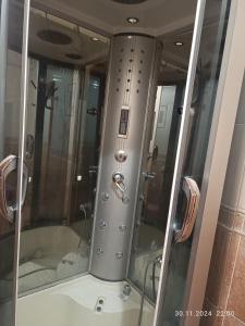 a shower with a glass door in a bathroom at Достык Хостел in Almaty