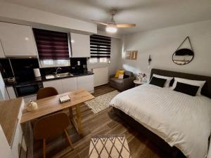 a bedroom with a bed and a table and a kitchen at The Calm Retreat in Tríkala