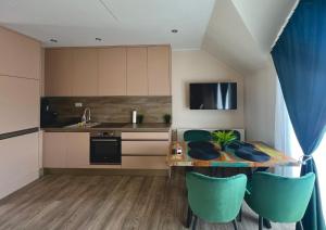 a kitchen with a table and some blue chairs at Mirina Apartmanok in Vonyarcvashegy