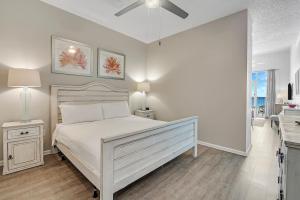 a white bedroom with a bed and a ceiling fan at Windemere 301 in Perdido Key