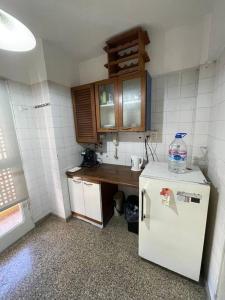 a small kitchen with a refrigerator with a bottle of water on it at Departamento amoblado, en centro in San Juan +4 photos
