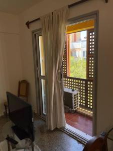 a living room with a television and a sliding glass door at Departamento amoblado, en centro in San Juan