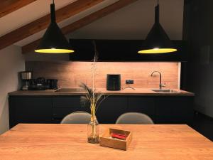 een keuken met een houten tafel met een aanrecht en 2 verlichting bij Residence Pranterhof in Marlengo