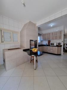 a kitchen with a table with a bowl of fruit on it at Casa para 19 pessoas a 30 min Beto Carrero in Piçarras