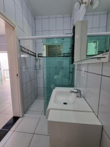 a white bathroom with a sink and a shower at Casa para 19 pessoas a 30 min Beto Carrero in Piçarras