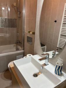a bathroom with a white sink and a mirror at Victoria Condo Otopeni- Self Check-in and Check- out in Otopeni +15 photos