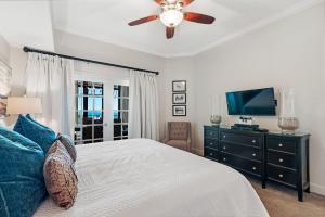 a bedroom with a bed with a ceiling fan and a television at Phoenix West 2005 in Orange Beach