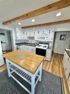 a kitchen with white cabinets and a wooden table at GRANDVIEW LAKEFRONT LIMIT 9 villa in North Sebago