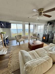 a living room with a couch and a ceiling fan at GRANDVIEW LAKEFRONT LIMIT 9 in North Sebago +14 photos