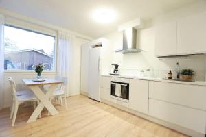 KauhajokiにあるHuoneisto kaupungissa Kauhajokiの白いキッチン(テーブル付) +5枚の写真