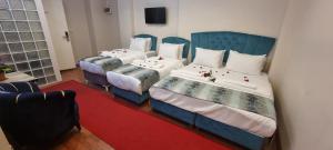 two beds in a room with a red rug at By Historial Hotel Due in Istanbul