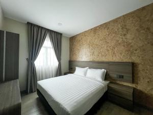 a bedroom with a large white bed and a window at E Hotel Kulim in Kulim