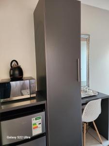 a kitchen with a microwave and a table with a chair at Oblique Boutique House in Centurion