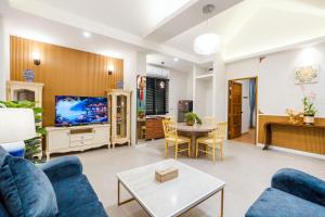 ein Wohnzimmer mit blauen Sofas und einem Fernseher in der Unterkunft Full moon Bay hua hin Cha-am in Sathani Huai Sai Tai