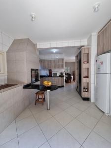 a kitchen with a white refrigerator and a table at Casa para 19 pessoas a 30 min Beto Carrero in Piçarras
