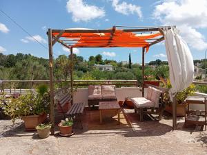 an orange umbrella and chairs on a patio at Gasphouse in Castellana Grotte