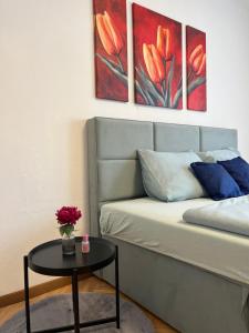 莱奥本Gemütliche Stadtwohnung Leoben, Gratis Parkplätze的一间配有沙发的房间和一张鲜花桌子