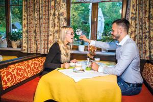 a man and woman sitting at a table in a restaurant at Gasthof Zinkenbachmühle in Sankt Gilgen