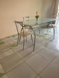a glass table and chairs on a tiled floor at Araujo in Governador Valadares