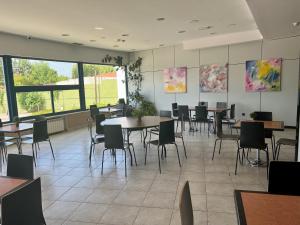 a dining room with tables and chairs and windows at AP Hotel Madrid Airport in Madrid