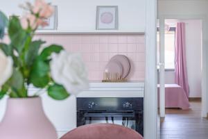 a kitchen with a fireplace and a pink tile wall at Casa Vacanze Maddalena - Palazzetto sul lago - Diamante Rosa in Marta +39 photos