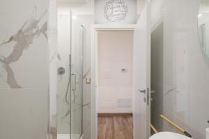 a white bathroom with a shower and a toilet at Rosso Rubino - Mansarda Vista Lago a Marta in Marta +34 photos