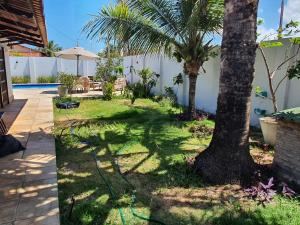einen Garten mit einer Palme und einem Schlauch in der Unterkunft Casa Colorida em Touros in Touros