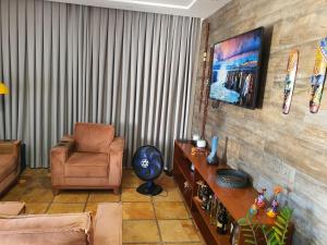 ein Wohnzimmer mit einer Couch und einem Sessel in der Unterkunft Casa Colorida em Touros in Touros