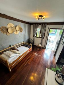 een slaapkamer met een bed en een houten vloer bij Morada da Xica in Guarda do Embaú +27 foto's
