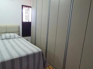 ein Schlafzimmer mit einem Bett mit einer gestreiften Decke in der Unterkunft Casa Colorida em Touros in Touros + 26 Fotos