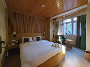 a bedroom with a large bed with a wooden ceiling at Happy Heart Stayover in Gangtok