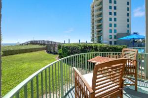 a balcony with two wooden chairs and a building at Perdido Towers East 106 in Perdido Key