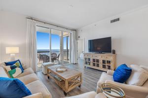 a living room with a couch and a tv and a table at Spanish Key 604 in Perdido Key