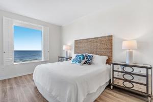 a bedroom with a bed and a window with the ocean at Spanish Key 604 in Perdido Key +42 photos