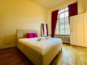 a bedroom with a bed with pink pillows and a window at Manneken View in Brussels